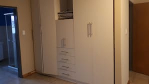 A room with a white wardrobe, a door, and a tiled floor. - C- Land Guest house Meyerton (Meyerton)