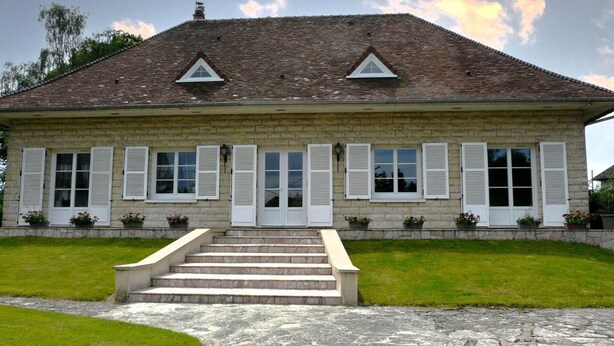 A stone building with a tiled roof, white shutters, and a central staircase leading to a door. - Charming Stone House in Calm Senonches - Modern Amenities & Large Garden (Senonches)