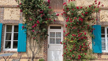 A building with a brick facade, a white door, and blue shutters.