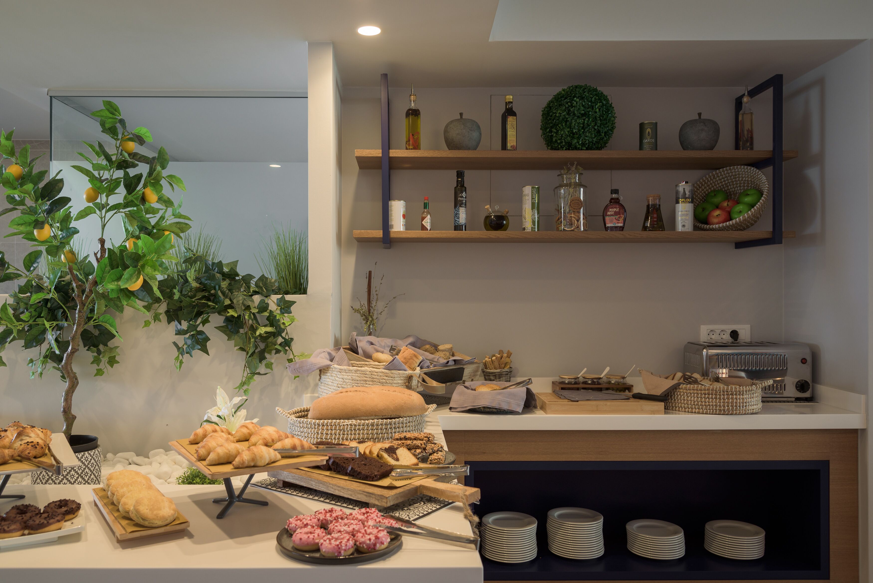 Ein reichhaltiges Buffet mit verschiedenen Speisen, einem Toaster und einer Ablage mit Flaschen und Früchten.