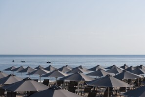 A beachside area with rows of umbrellas and chairs, likely part of a resort or hotel. - Bio Beach Boutique Hotel (Rethymno)