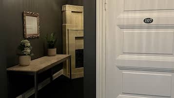 A hallway with a bench, a mirror, and a door marked with the number 107.