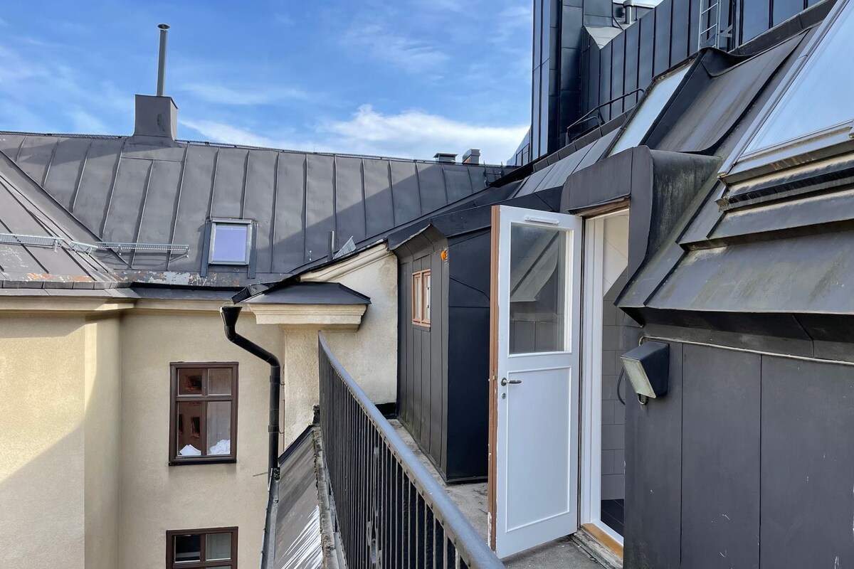 A residential building with a metal roof, a white door, and a window.