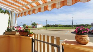 A covered outdoor area with a view of a parking lot and a building in the background.