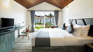 Een moderne hotelkamer met een groot bed, een flatscreen televisie, een bureau en uitzicht op het buitengebied.