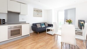 A modern apartment with a kitchen, a dining area, and a living room. - Skyvillion Apartments - TowerPoint Enfield - 1Bed Deluxe Apartment w/ Balcony (Greater London)