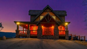 A large, two-story log cabin with a prominent front porch and a stone foundation. - Rockin' Ridge Retreat: Indoor Pool, Mtn Views, Home Theater, Games, Signature, near Attractions! (Sevierville)