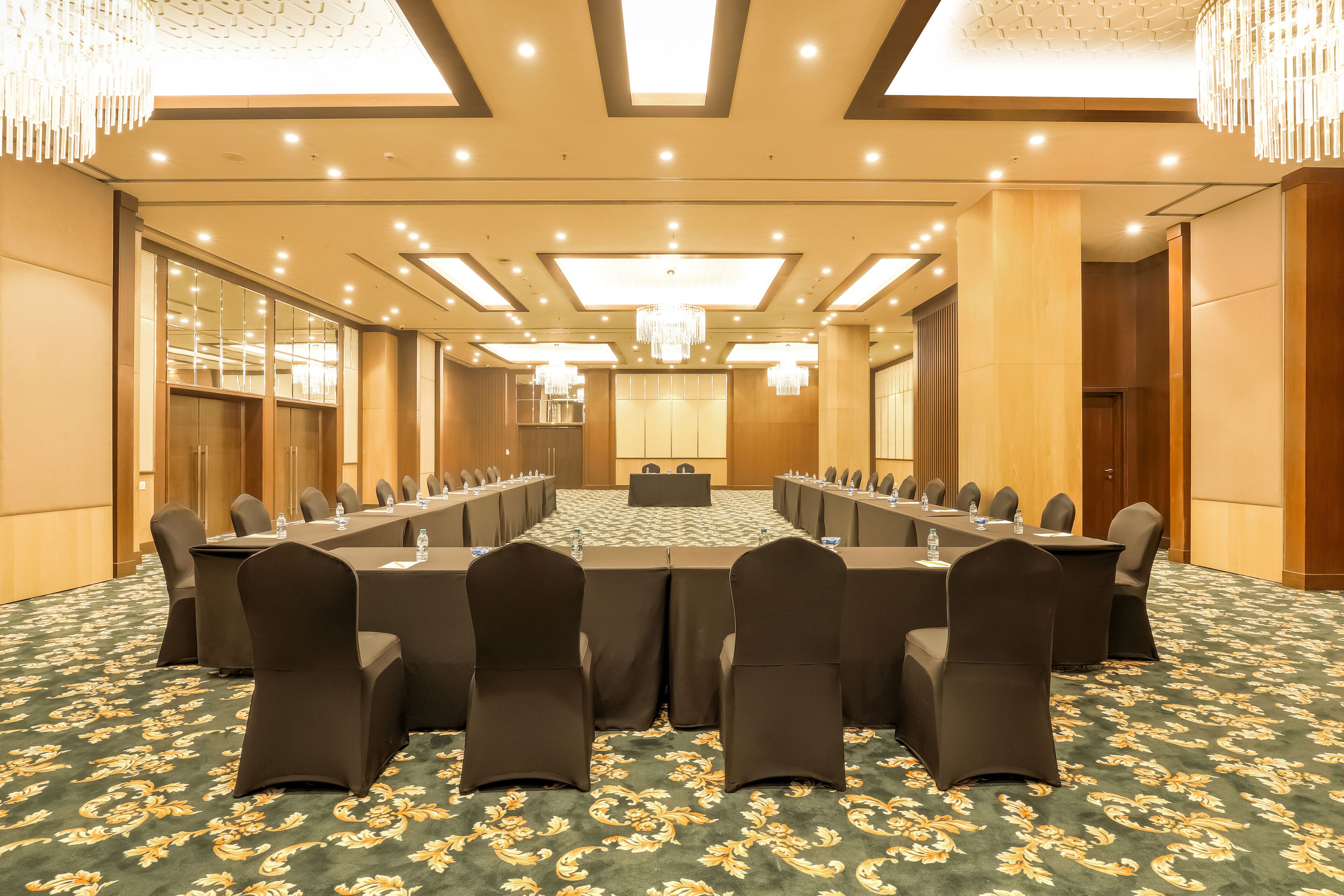 Una sala conferenze con un lungo tavolo, sedie e pavimento tappezzato.