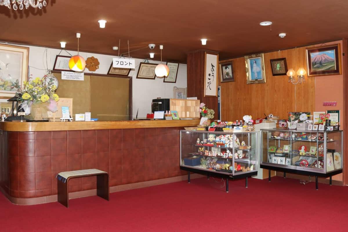 Uma área de recepção com balcão de madeira, quadros com certificados e uma exposição de lembranças.