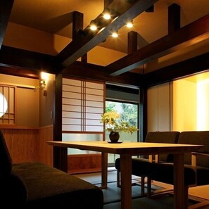 A traditional Japanese room with tatami flooring, a low table, and a sliding door. - Motoyu Yamadaya Ryokan (Hitachiota)