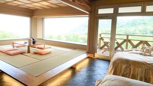 Una habitación con esteras de tatami, una mesa baja, cojines y una cama.