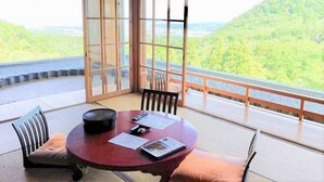 Una mesa redonda con sillas y vistas a un paisaje montañoso.