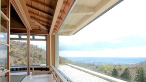 Una habitación con techo de madera y amplias ventanas que dan a un paisaje pintoresco.