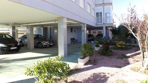 Een meerlaags parkeergarage met verschillende geparkeerde auto's, waaronder een Mercedes-Benz.