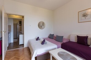 A bedroom with a bed, a bedside table, a mirror, and a framed picture on the wall.
