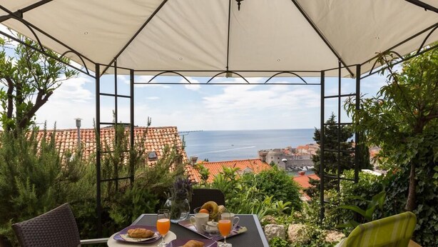 Ein Frühstückstisch mit Blick auf das Meer und Gebäude im Hintergrund.
