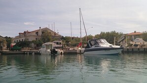 Ein Yachthafen mit vertäuten Booten, ein Gebäude mit rotem Dach und ein klarer Himmel.