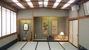 A traditional Japanese room with tatami flooring, sliding doors, and a shoji screen. - Hinode Ryokan (Fukui)