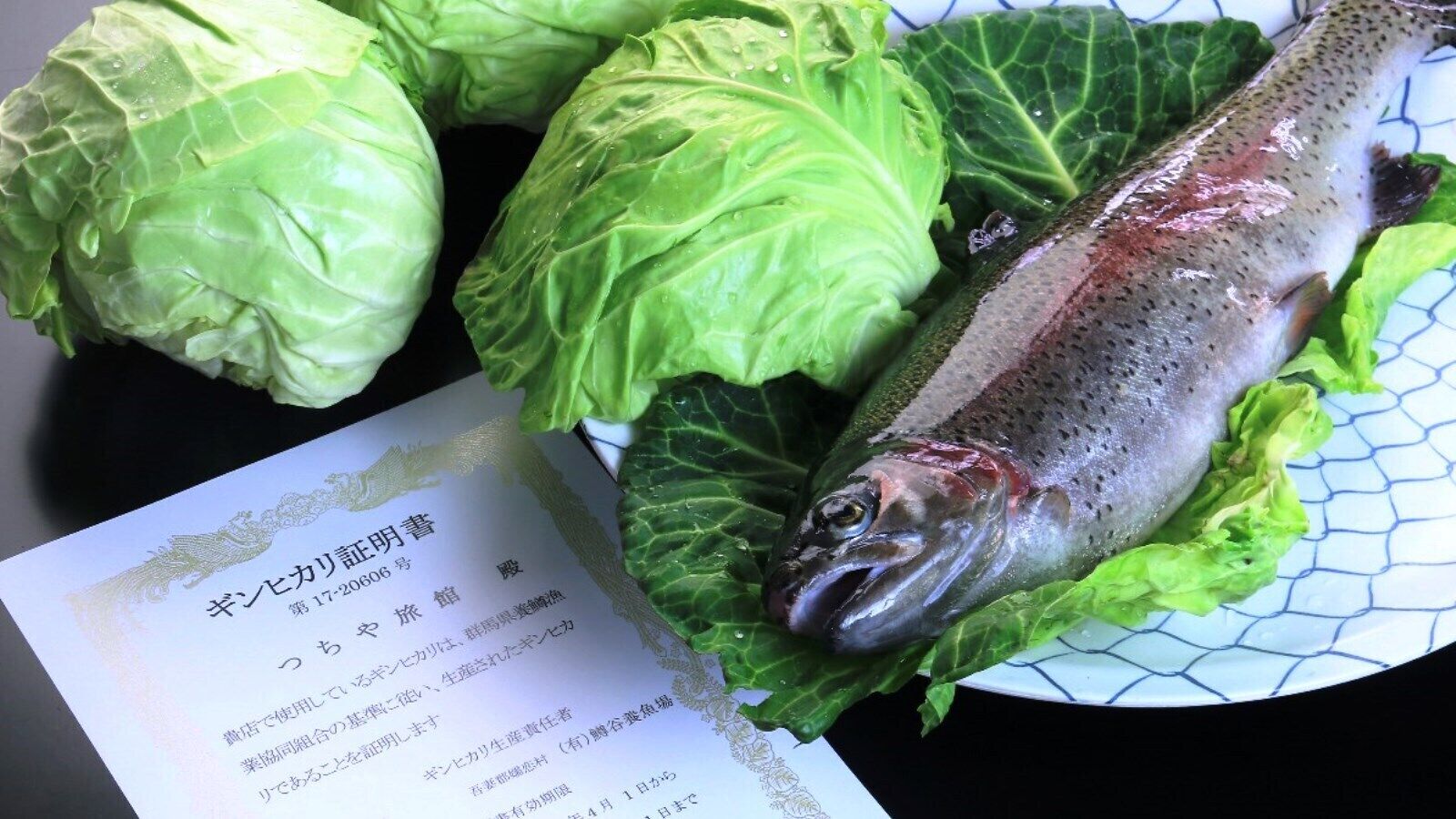 A plate with a fish, cabbage, and a menu.