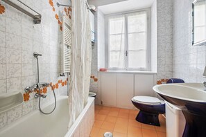 Une salle de bain avec une baignoire, des toilettes et un lavabo.
