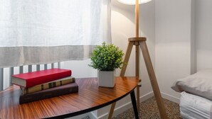 A room with a wooden table, a potted plant, and a floor lamp. - Inner City Apartments (Lecce)