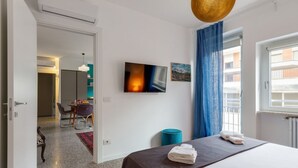 A hotel room with a bed, a television, a painting, and a window with curtains. - Inner City Apartments (Lecce)