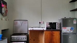 Eine Küche mit Gasherd, Mikrowelle und Kühlschrank.