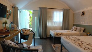 Ein Hotelzimmer mit Bett, Schreibtisch, Stuhl und Blick ins Freie.