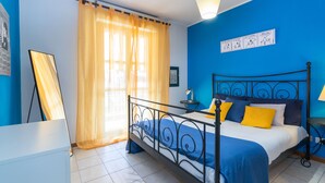 Une chambre à coucher avec un lit, des rideaux, une table de chevet et une lampe.