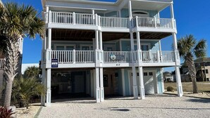 A multi-story building with balconies, a sign indicating 'Lucky Old Sun,' and a clear blue sky.