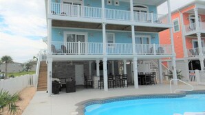 A multi-story hotel with balconies, a pool, and outdoor seating.