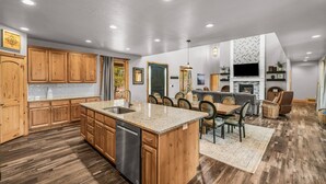 A spacious kitchen with wooden cabinets, a granite countertop, and a built-in dishwasher. - East Zion Trails Retreat: Your Gateway to Zion (Orderville)