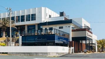 A modern building with a restaurant named 'Cousins Marin' on the ground floor.