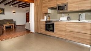 A modern kitchen with wooden cabinets, a microwave, an oven, and a coffee maker. - Villa for 7 (Xabia)