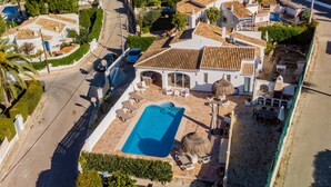An aerial view of a residential area with a swimming pool, white houses, and a curved road. - Villa for 7 (Xabia)