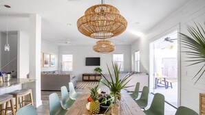 A spacious dining area with a wooden table, green chairs, and a central decorative plant. - Sleeps 20! 5 Min Walk to Beach, Private Pool & Hot Tub, 8BDR | Lyle by AvantStay (Destin)