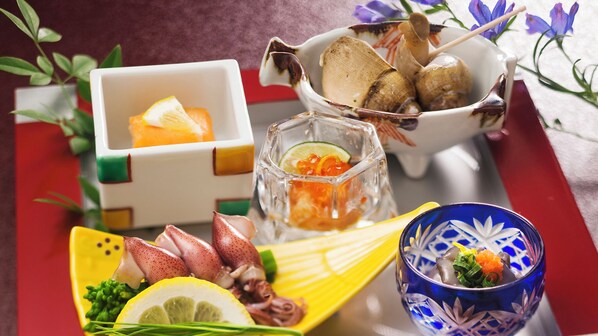 A tray with various food items, including seafood and a glass with a drink.