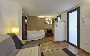 Relax in a spacious room with a bathtub, sink, and mirror.