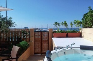 Enjoy breathtaking views of the marina and sea from this rooftop retreat, featuring a hot tub and comfortable seating area.