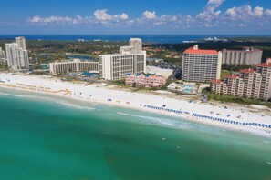 A coastal hotel with multiple high-rise buildings, a beach with umbrellas, and a clear view of the ocean. - Deja Blue Too Studio at Tops'l, Pool, Beach (Miramar Beach)