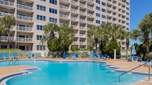 A pool area with blue lounge chairs and a large building with balconies in the background. - Deja Blue Too Studio at Tops'l, Pool, Beach (Miramar Beach)