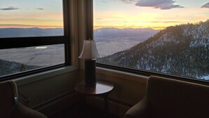 A room with a large window offering a view of a valley and mountains during sunset. - Experience Tahoe's Ski Scene at Holiday Inn Club Vacations Tahoe Ridge Resort (Stateline)