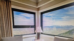 A corner room with two large windows offering a mountain view, a small round table, and a sofa. - Experience Tahoe's Ski Scene at Holiday Inn Club Vacations Tahoe Ridge Resort (Stateline)