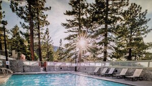 A swimming pool with lounge chairs and a stone wall. - Experience Tahoe's Ski Scene at Holiday Inn Club Vacations Tahoe Ridge Resort (Stateline)