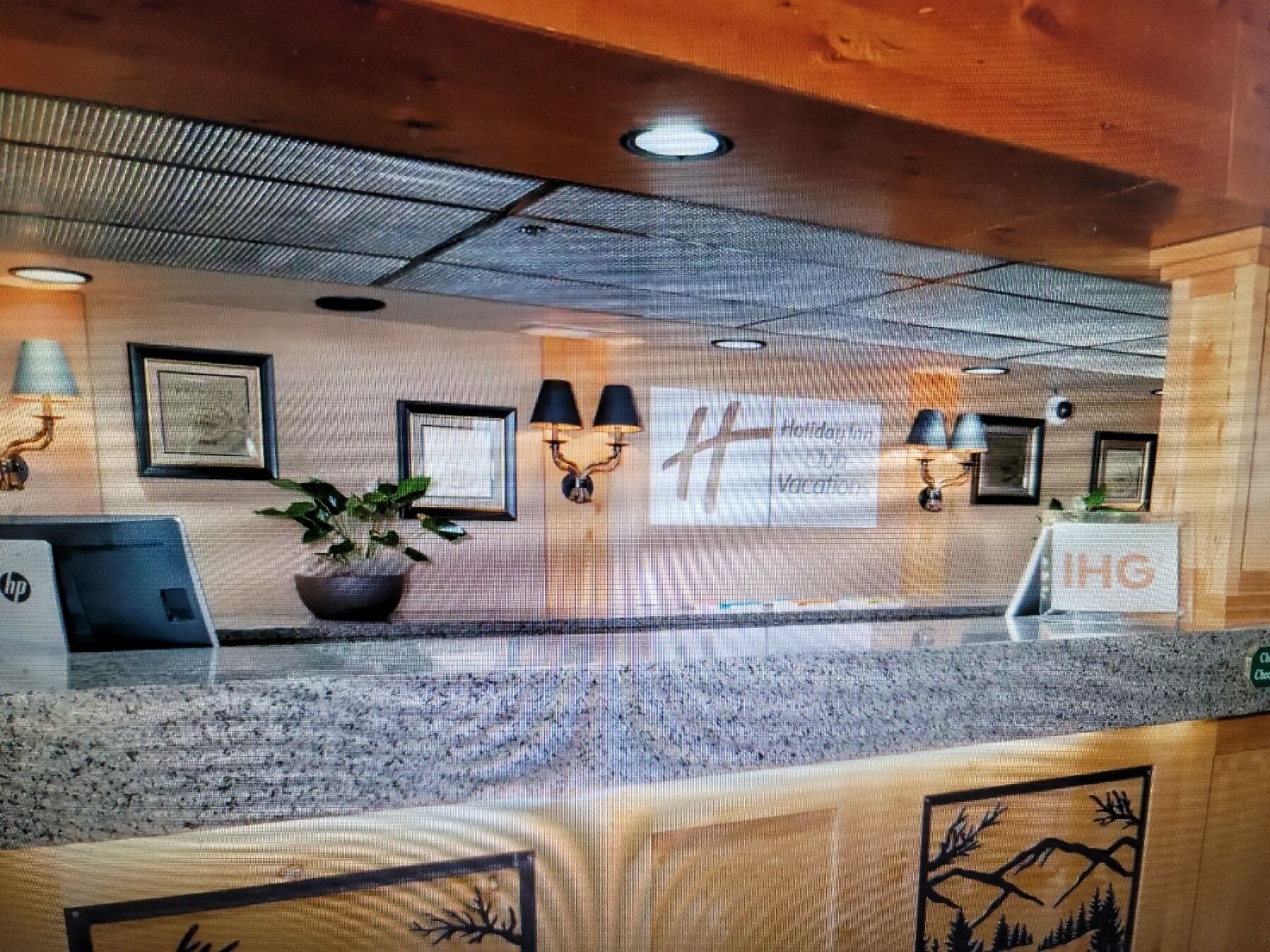 A reception desk with framed artwork, a potted plant, and a sign for 'Holiday Inn Express'.