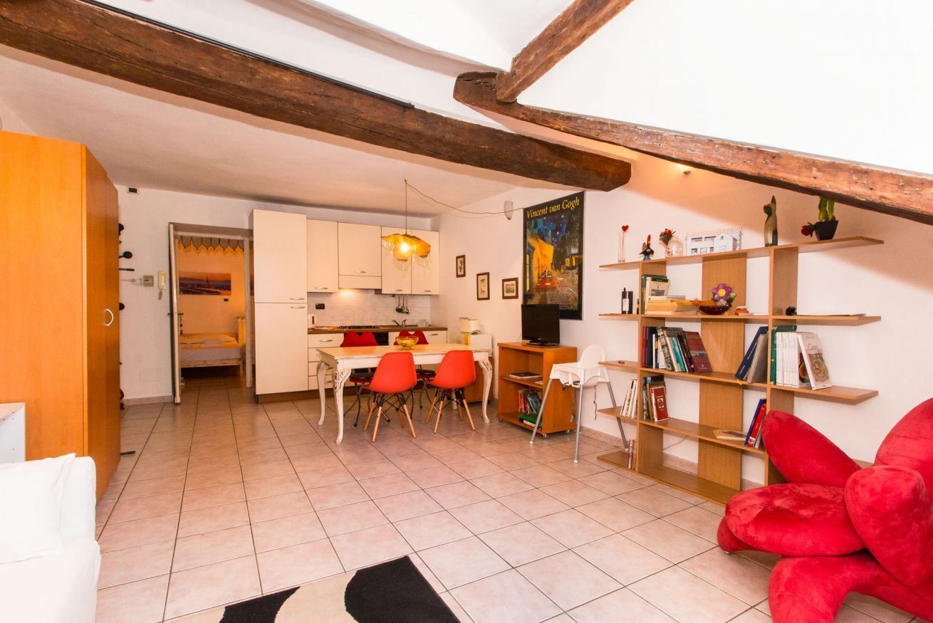 A compact living space with a kitchen, dining area, and a bookshelf.