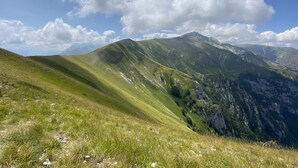 Un paisaje montañoso con colinas onduladas y un cielo despejado.