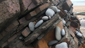 A rocky cliff with smooth stones and a beach in the background. - Lovely 3 Bedroom Holiday Bungalow Near Bude (Bude)