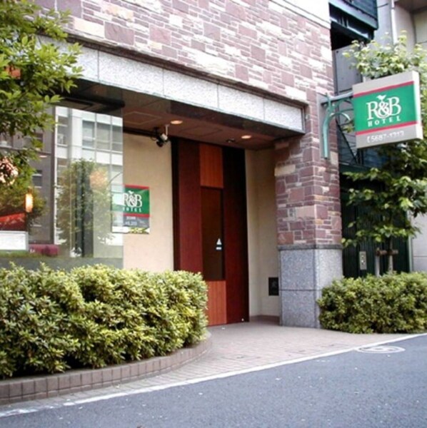 Welcome to the R&B Hotel, featuring a charming brick facade and beautifully manicured entrance.