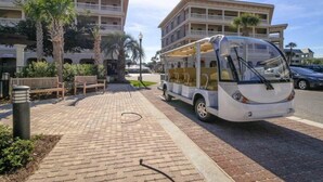 Un autobús estacionado en una zona pavimentada, con un edificio al fondo.
